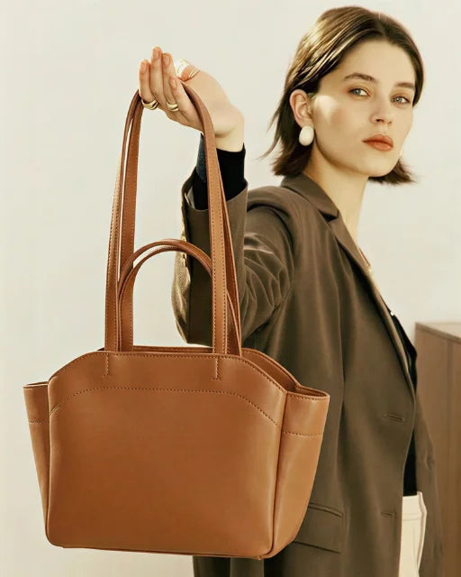 Zara Bag Brown – caramel brown wing tote held by model wearing a blazer